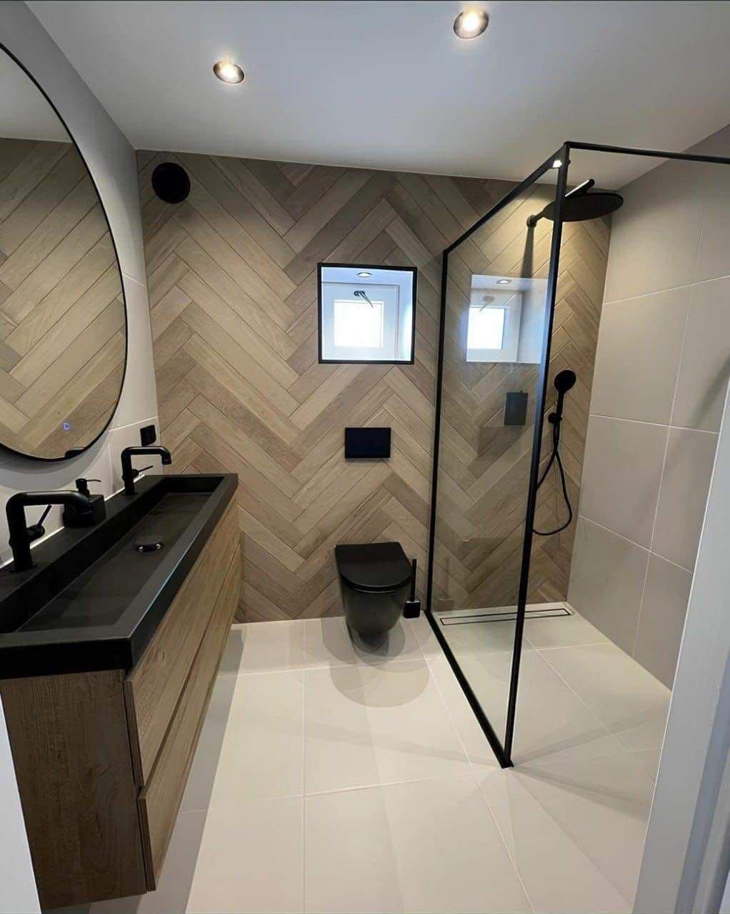 Custom shower with herringbone tile, black fixtures and a floating vanity