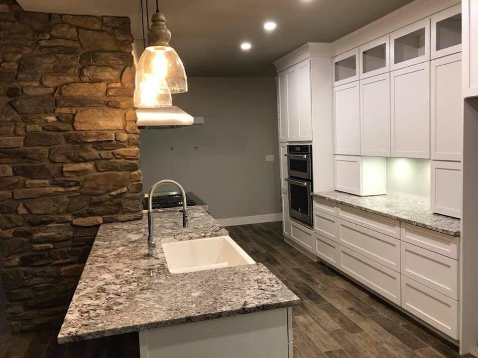 Kitchen island and cabinets beside a stone-clad structural column