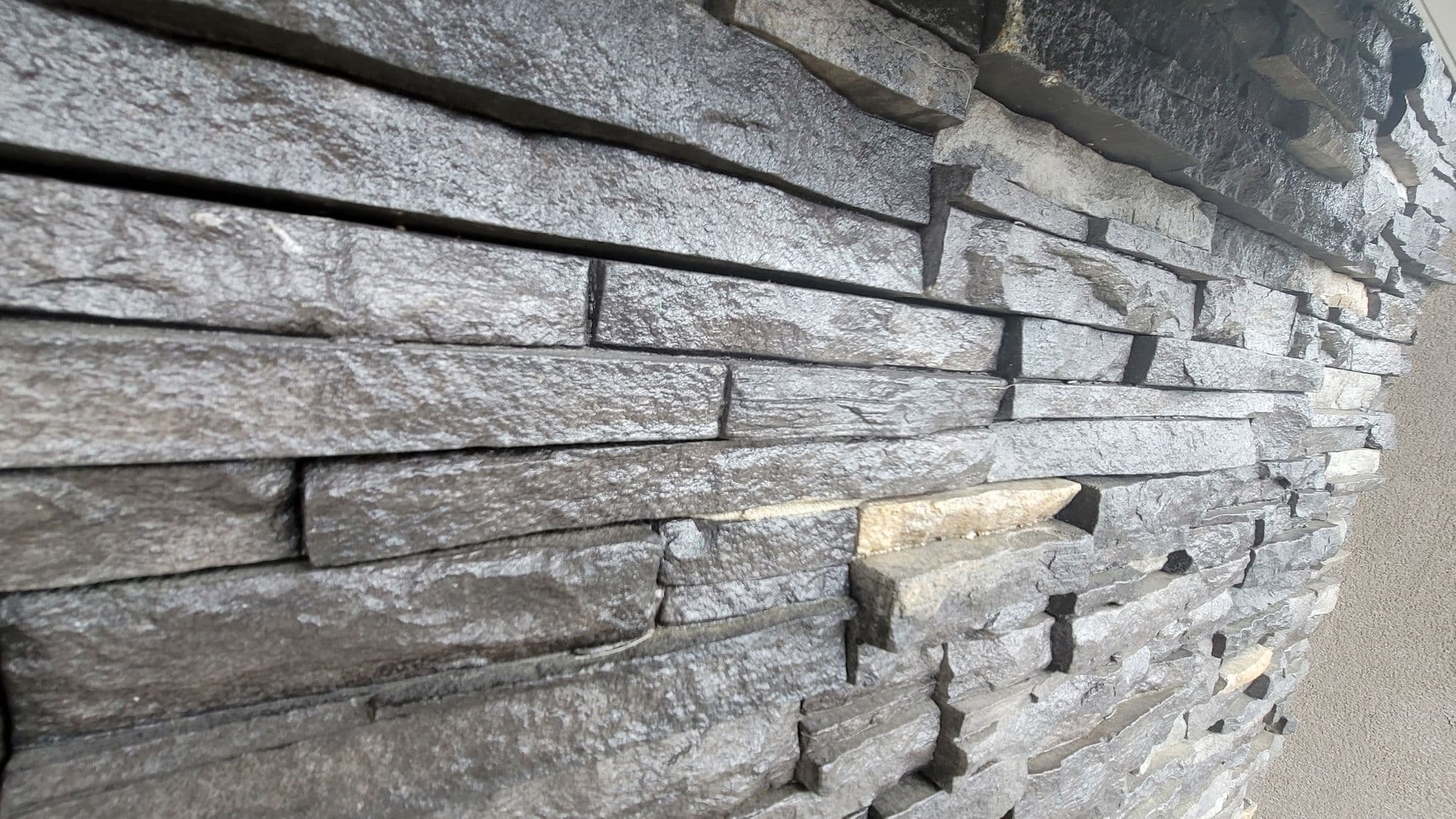 Close-up of dry-stack stone veneer with a raked joint under warm light