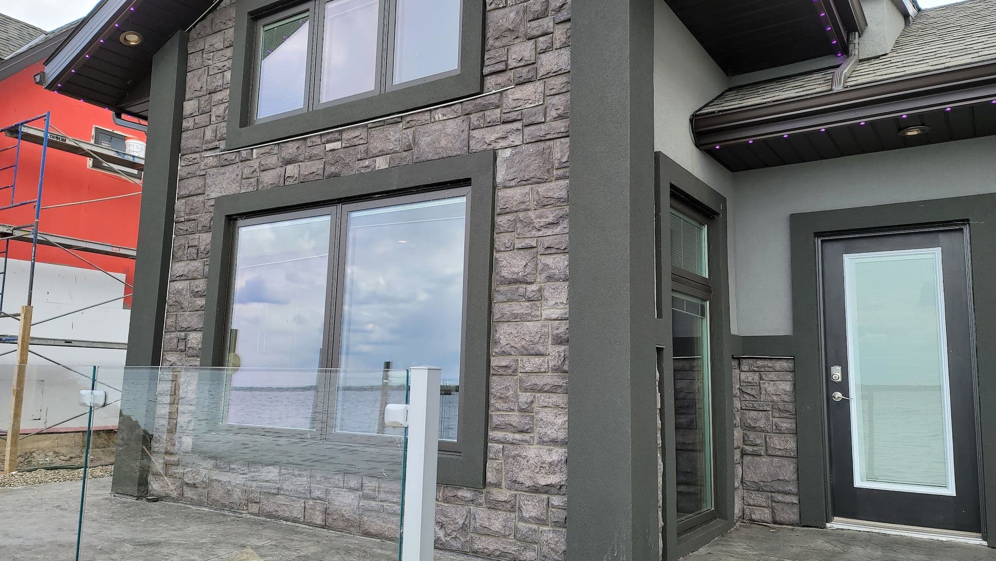 Stone corner detail meeting stucco on a modern home exterior