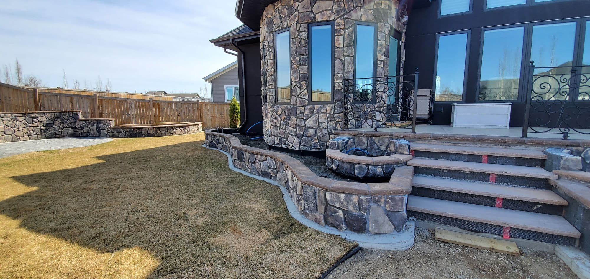 Stone facade with curved stone planter walls and stone-faced front steps
